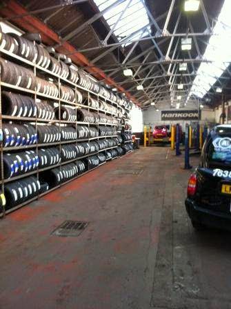 Looking down the workshop aisle at Nuneaton Exhaust Centre, a car in the bay at the far end